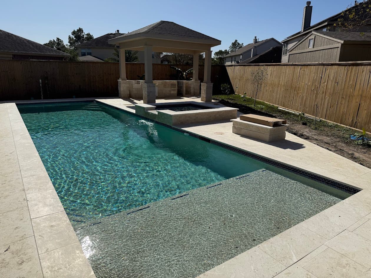 Backyard pool and travertine deck with an open gazebo, no covered patio over the main living area