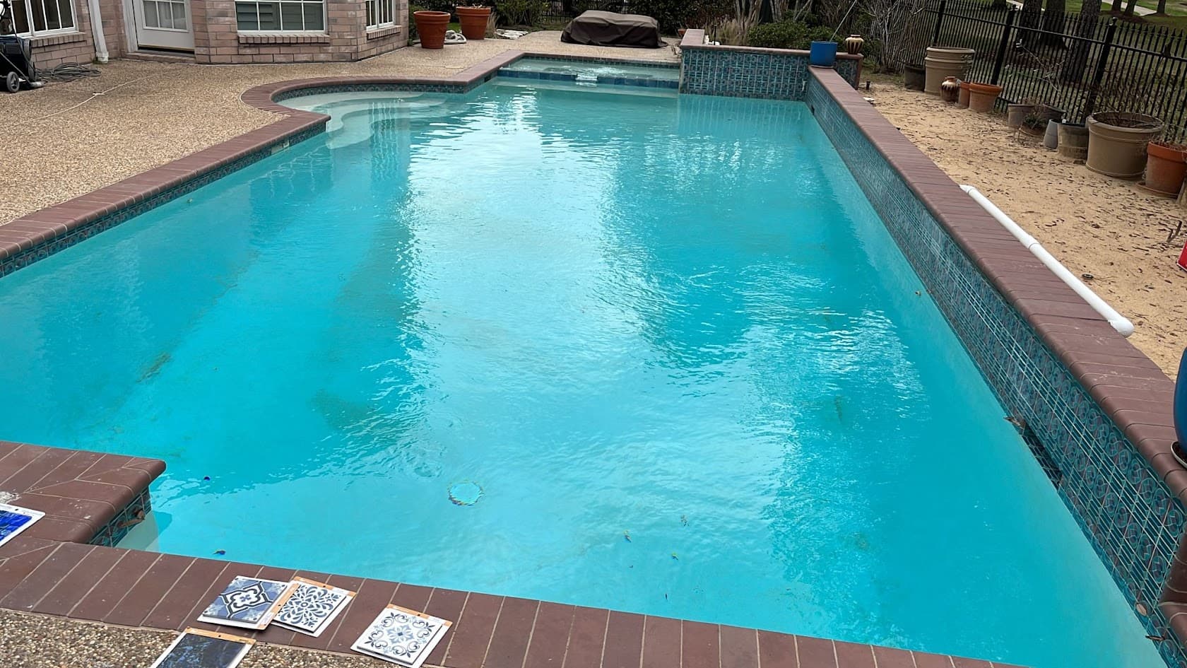 Pool before renovation with plain deck and no shade structure