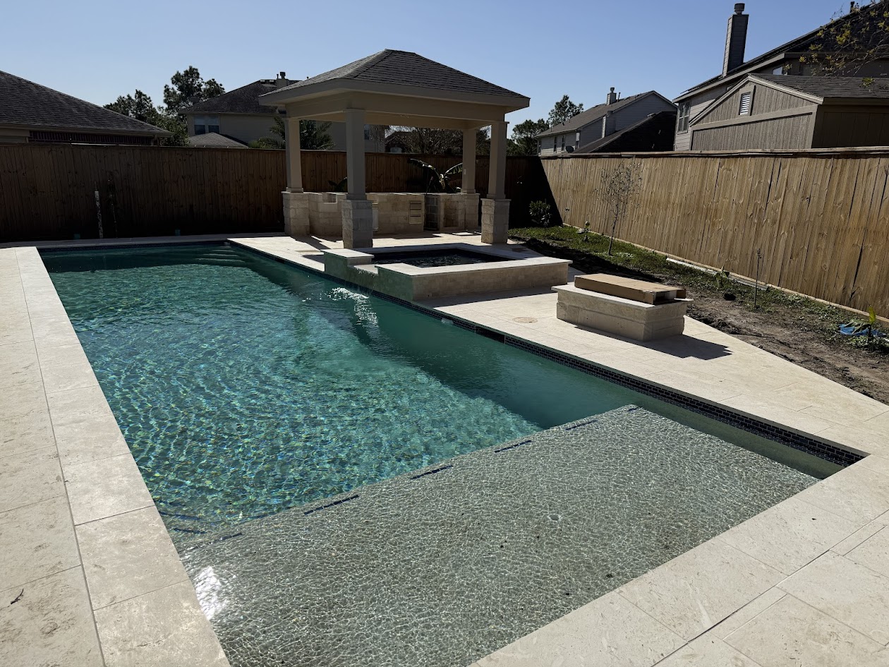 Backyard pool and travertine deck with an open gazebo, no covered patio over the main living area